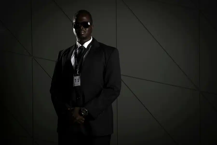 Un agent de sécurité en costume noir avec lunettes de soleil