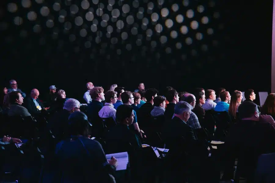Conférence professionnelle en salle sombre à Paris avec dispositif de sécurité événementielle et contrôle des accès