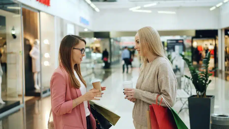 Deux femmes discutent dans un centre commercial