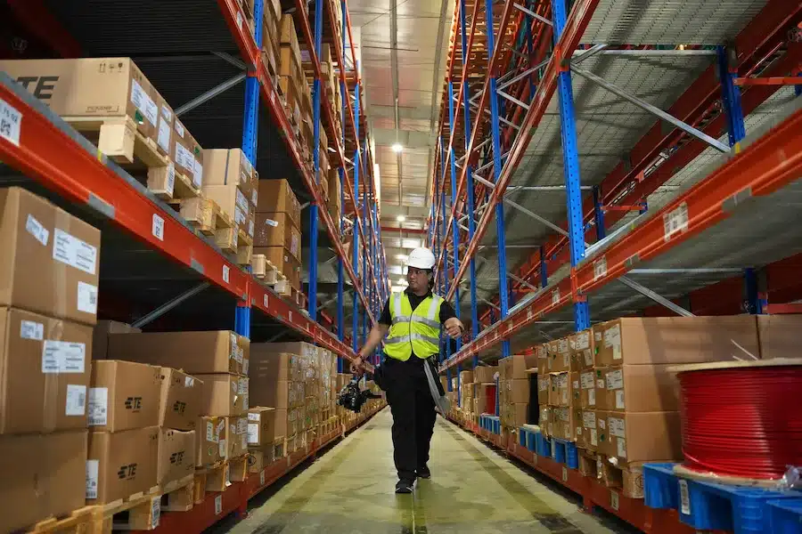 Ouvrier marchant dans un entrepôt, illustration de la logistique et de la sécurité des sites industriels à Paris