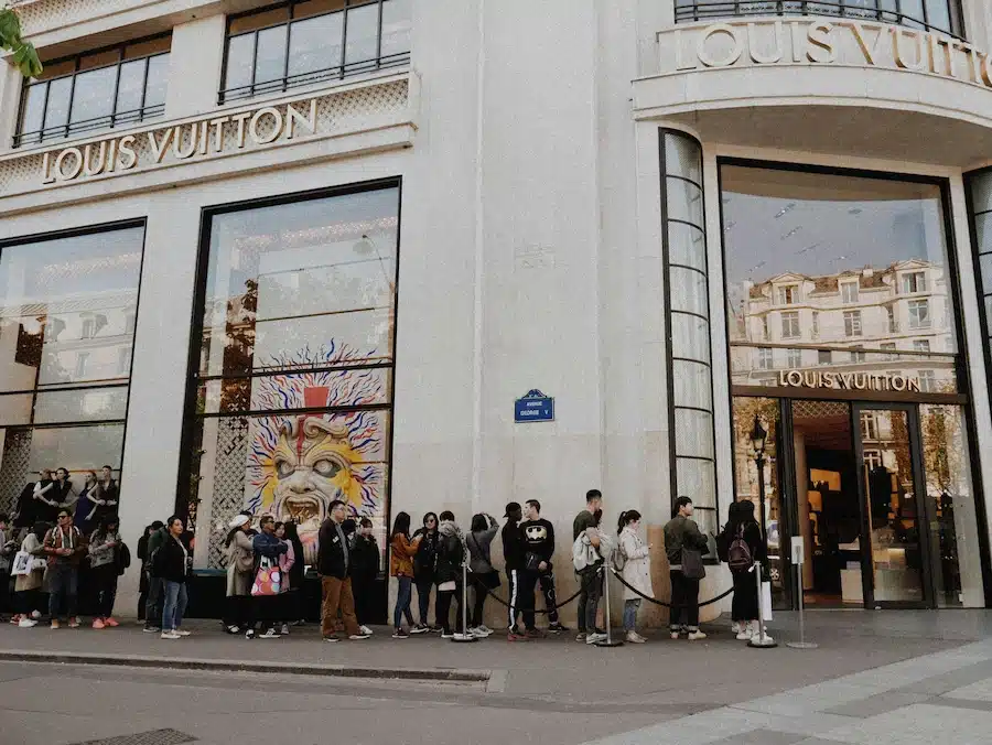 Une queue de clients devant la boutique Louis Vuitton sur l'avenue George V à Paris